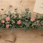 Art floral centre de table allongé, composition florale horizontale avec mousse et roses