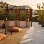 Déco pour terrasse : tapis extérieur beige, jardinières rose poudré, lanternes solaires