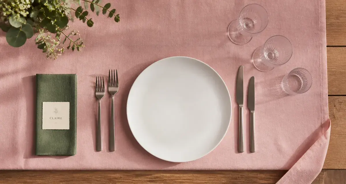 Dressage table à la française : nappe rose poudré, assiettes et couverts bien placés